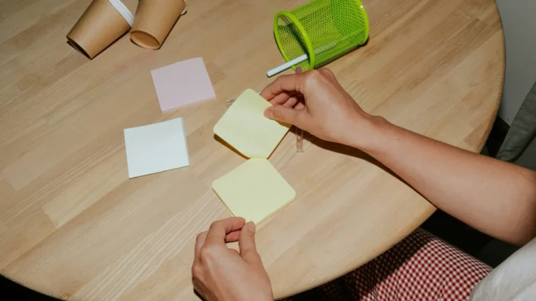 Hands writing goals on post-it notes with coffee - Upper-intermediate ESL lesson on New Year's resolution alternatives