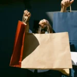 People holding large shopping bags, symbolizing Black Friday buying habits and consumer spending for this ESL lesson topic.