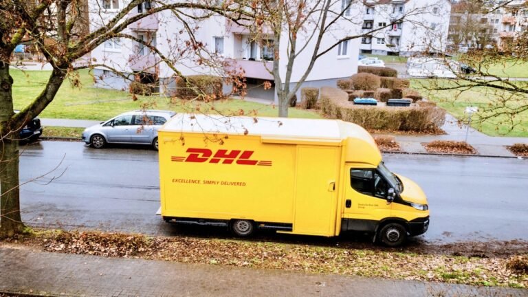 A yellow DHL delivery van parked on a quiet street in a residential area. The image represents Marcelo, a delivery driver from the Undercover Boss video, who works hard abroad to support his family. It connects to the lesson topic of “undercover work” and the challenges faced by people working far from home.
