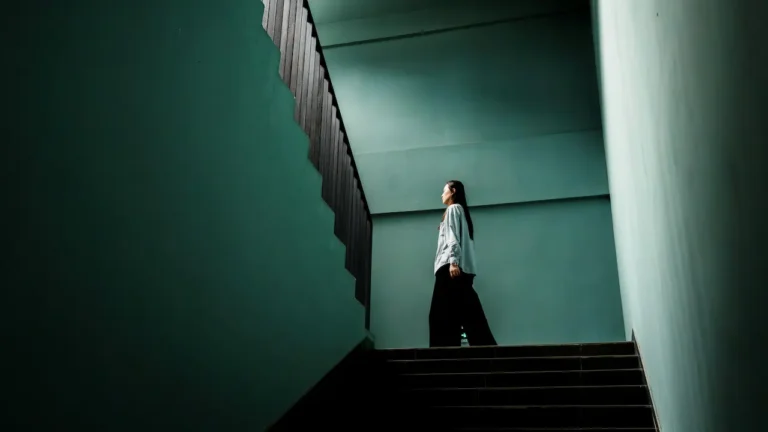 Woman standing on stairs contemplating time and life choices in free time ESL lesson about priorities and screen time habits