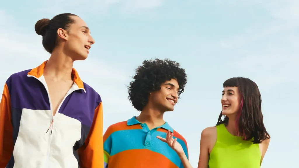 Three diverse young people smiling together outdoors, illustrating social connections in English articles for students.