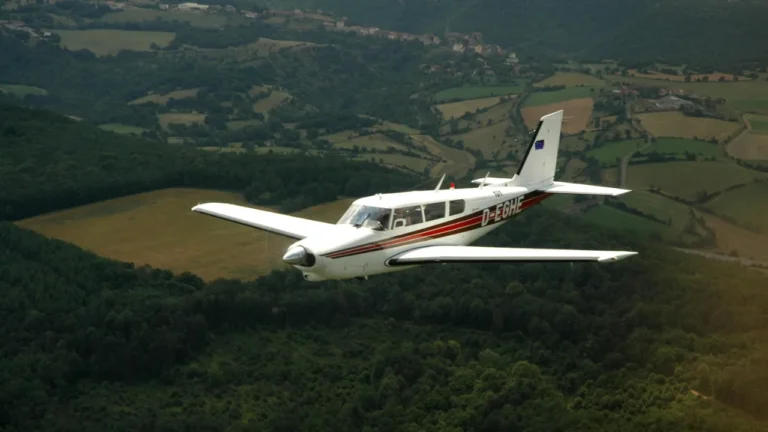 Small plane flying over countryside for B2 aviation lesson plan about pilots living in specialized flying communities