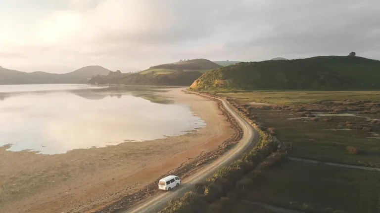 B1 English lesson plan featured image showing white van on scenic coastal road during golden hour for Road Trip to a New Life
