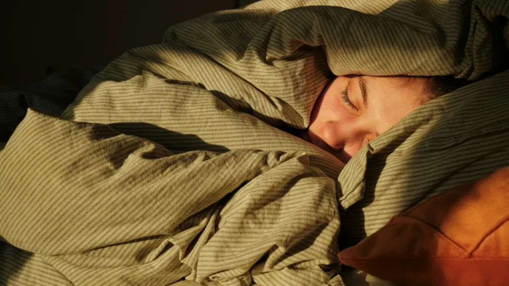 A person sleeping peacefully in bed — perfect image to introduce the B1 lesson plan on sleepcations.
