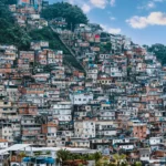 Densely packed favela houses covering a steep hillside in Rio de Janeiro, news lesson on favela tourism in Brazil.