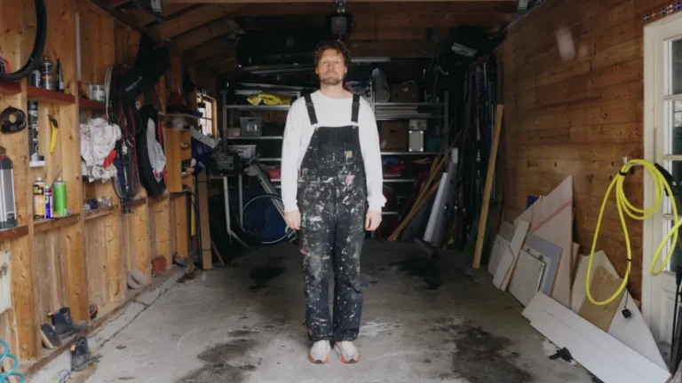 A man in paint-covered overalls stands in a garage in a still from the B1 ESL lesson plan "It Was Great Until It Wasn't."
