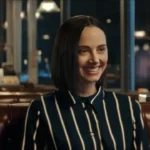 A smiling AI assistant in a diner scene from a satirical video used in this B2 lesson plan on AI ads.