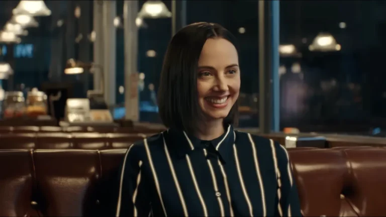 A smiling AI assistant in a diner scene from a satirical video used in this B2 lesson plan on AI ads.