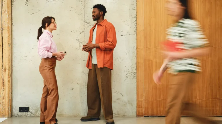 Two people having a casual conversation in an office hallway -- perfect for a British small talk lesson plan for A2 learners.