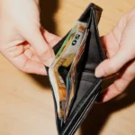 Hands opening a wallet with euro banknotes, used in a B1 lesson plan about cost of living and personal finances.