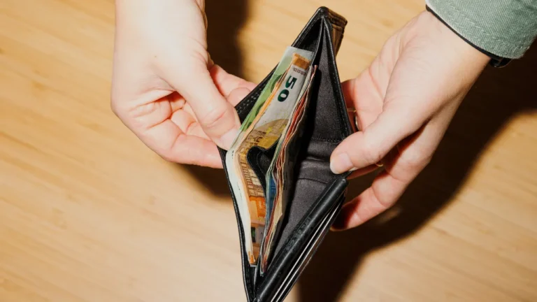 Hands opening a wallet with euro banknotes, used in a B1 lesson plan about cost of living and personal finances.