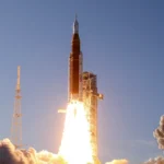 NASA Artemis rocket launches into blue sky, billowing smoke and flames at liftoff, space exploration lesson