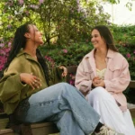 Two friends talking and smiling on a bench outdoors, used in a giving compliments A2 lesson plan for adult ESL learners.